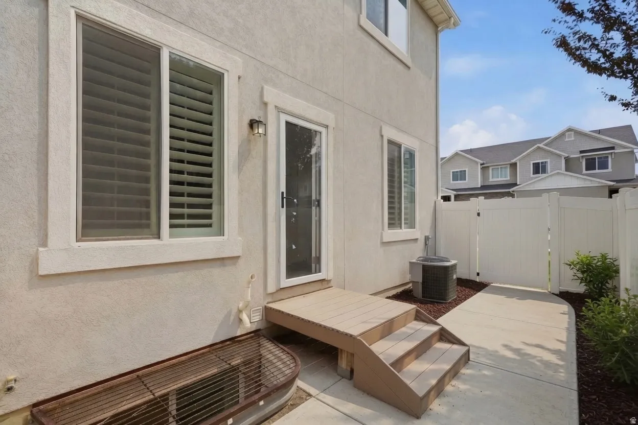 Rear exterior featuring a stucco finish, a private patio, and a secure vinyl fence
