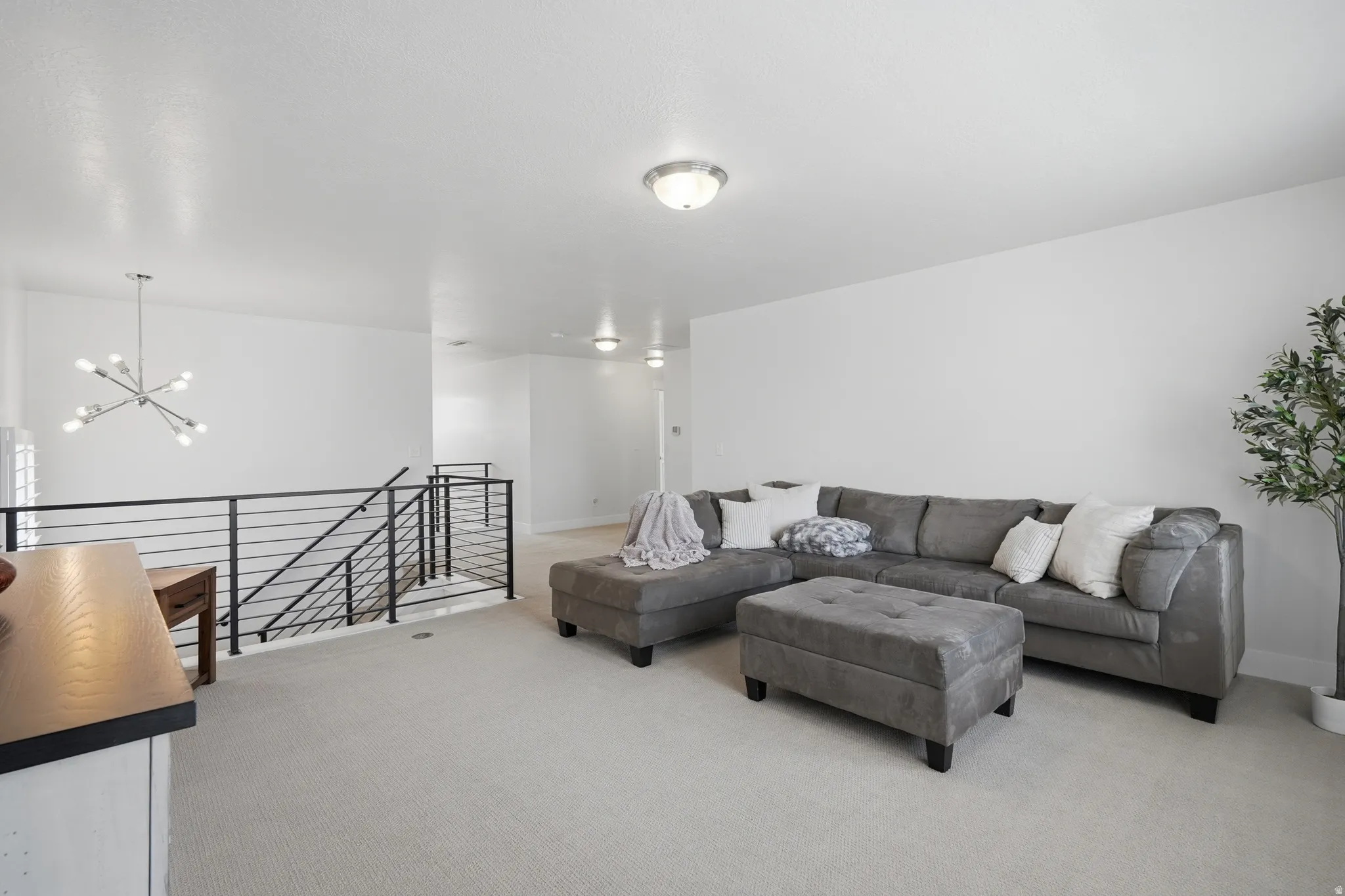 Open-concept living space with light-toned carpeting and neutral wall tones