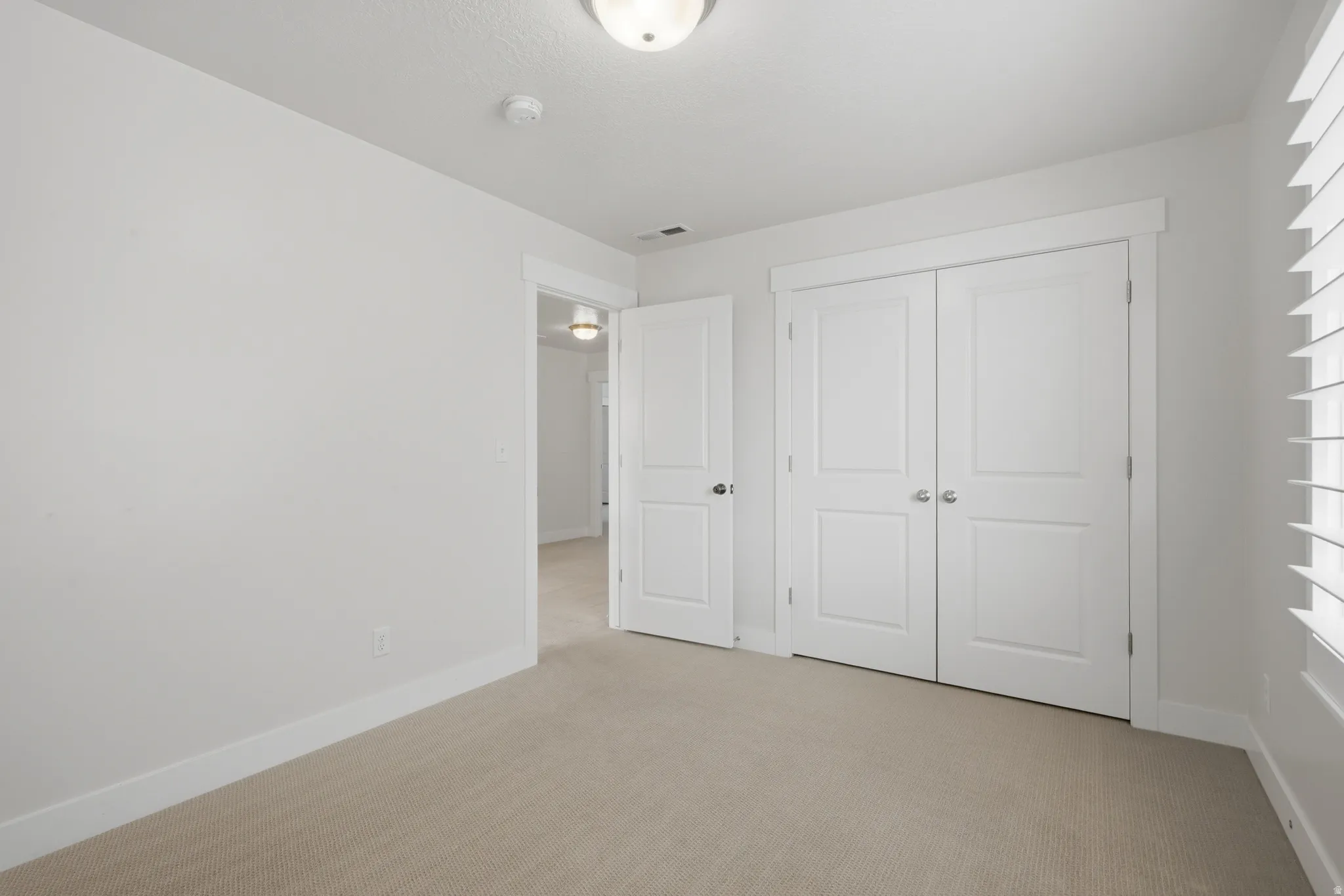 Neutral color palette with light beige carpeting and white walls