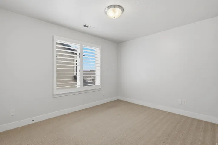 Room featuring a window with white plantation shutters