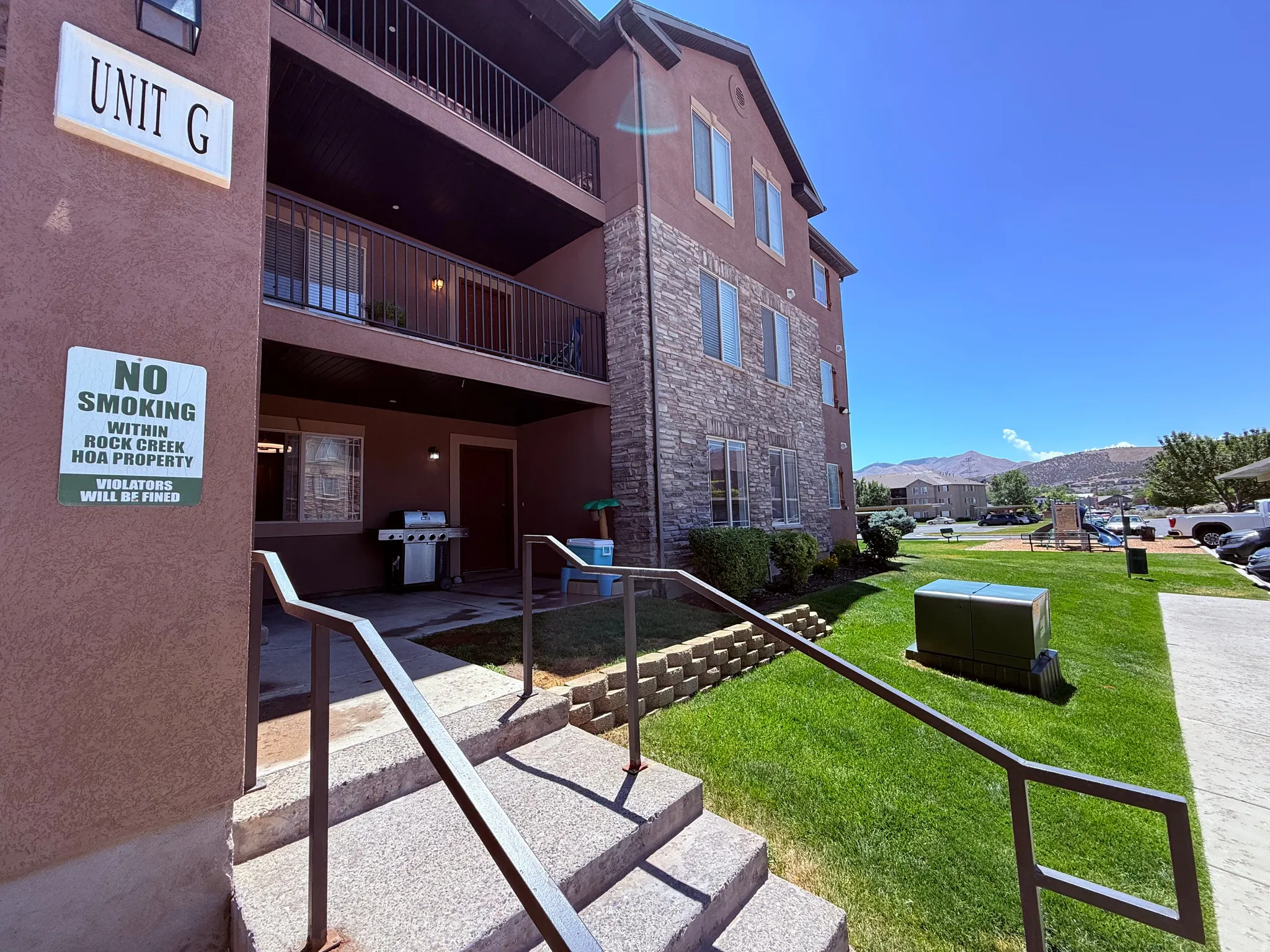 Three-story multifamily building featuring stone veneer and stucco siding