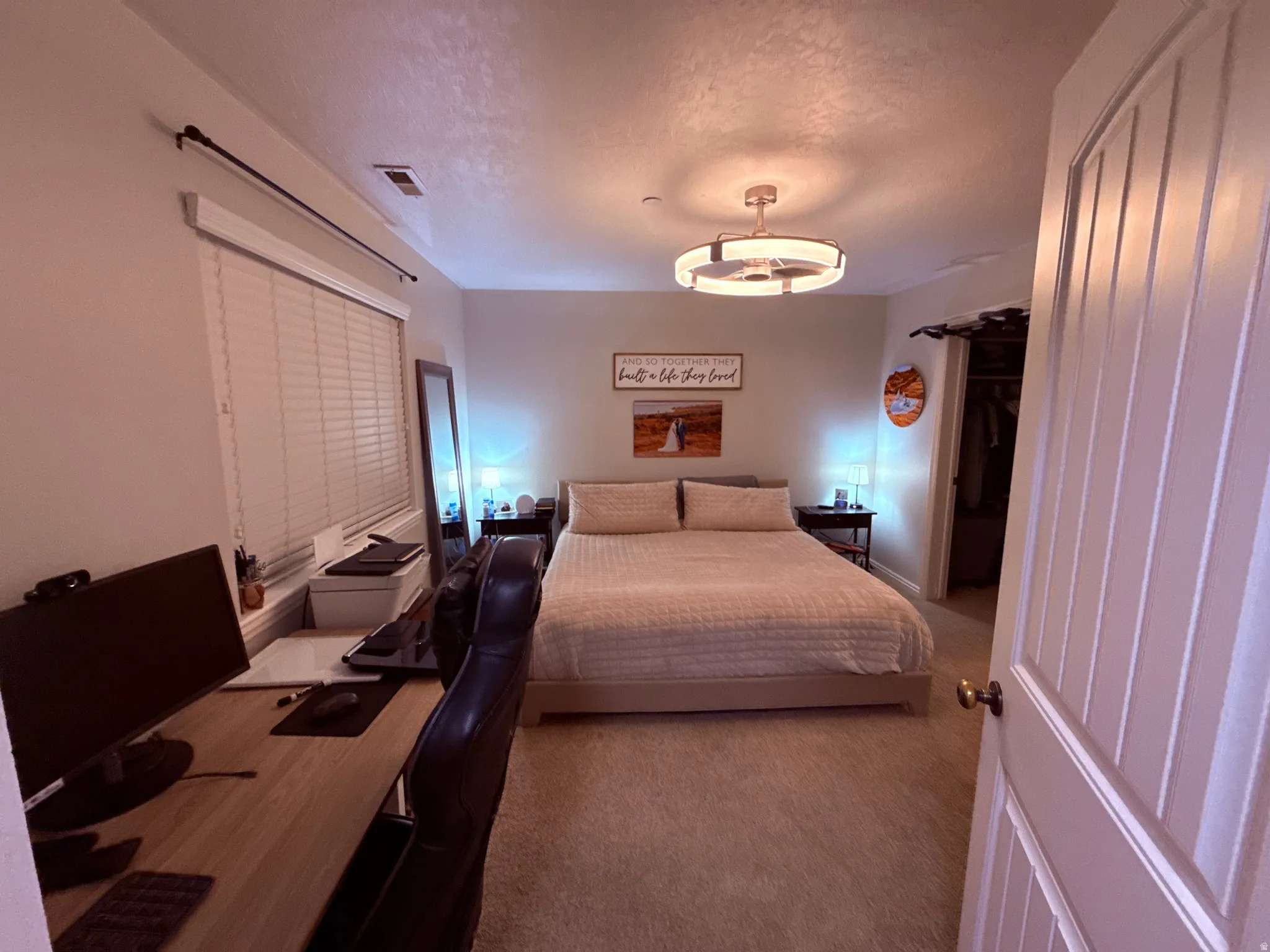 Carpeted room featuring a ceiling fan with integrated lighting, a window with blinds, and a built-in closet with a sliding door