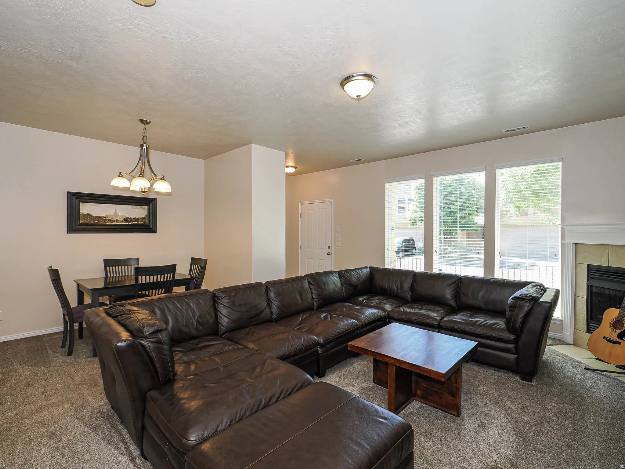 Open-concept living area featuring neutral-toned walls and carpet flooring