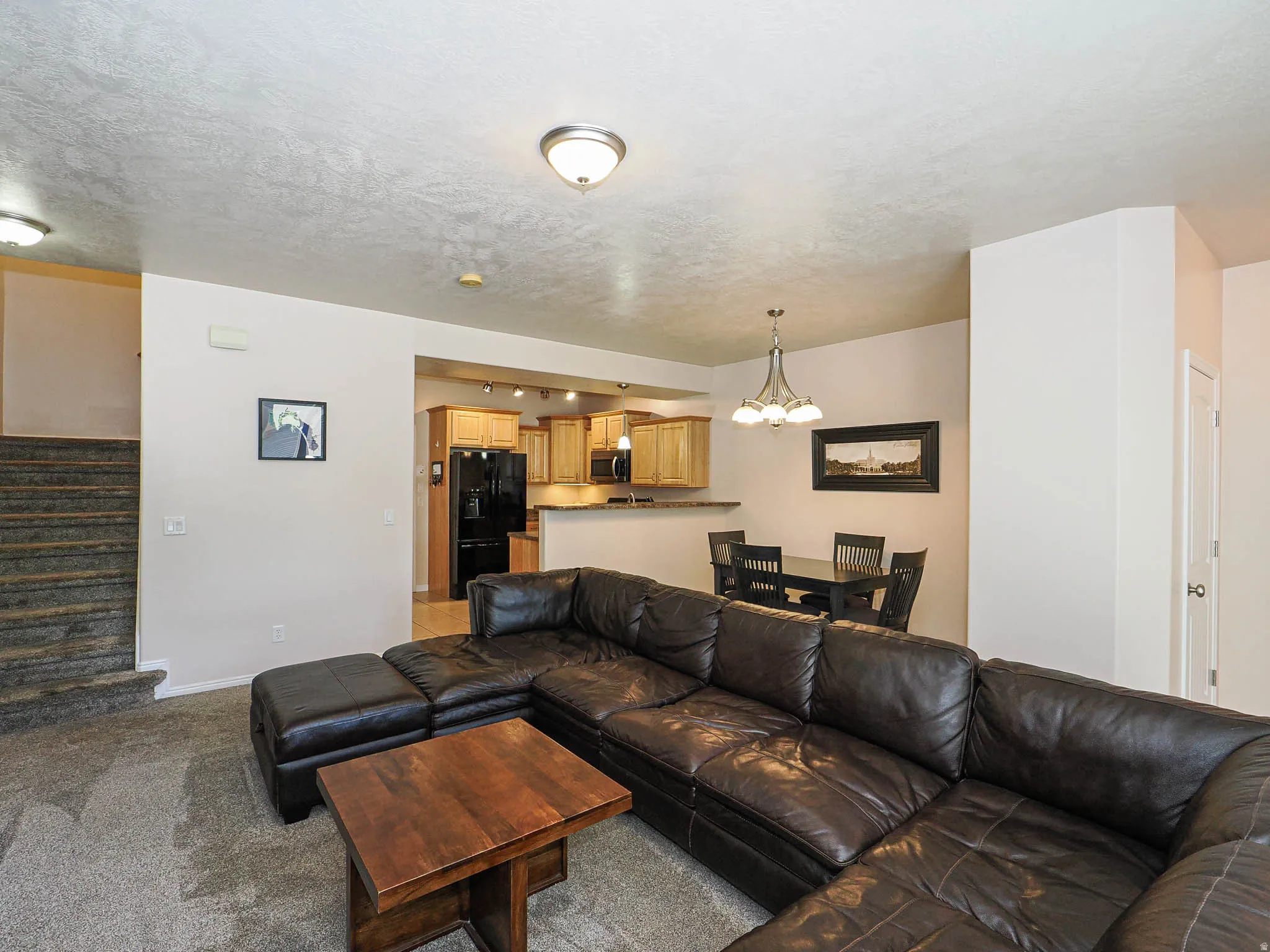 Open-concept living area with textured ceilings and overhead lighting