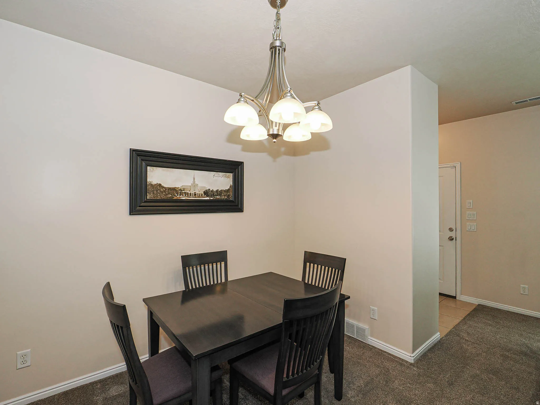 Dining area featuring neutral wall tones and a five-light chandelier