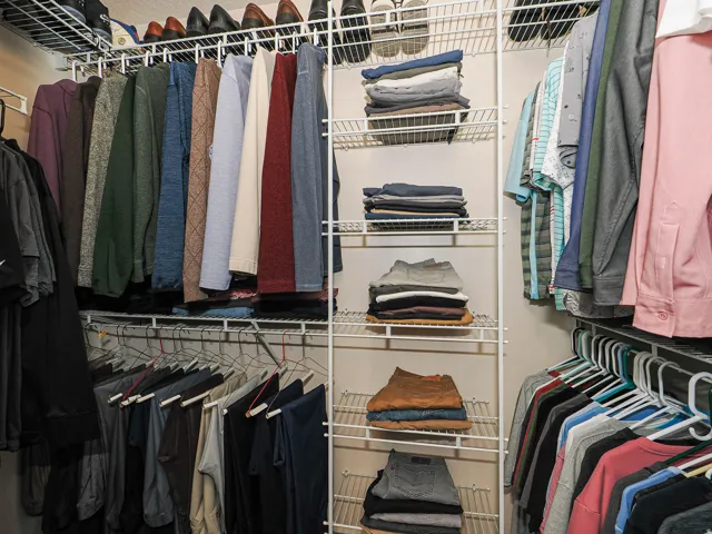 Integrated closet organization system featuring wire shelving and multiple hanging rods