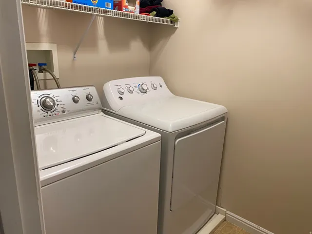 Dedicated laundry area featuring a top-loading washing machine and a white dryer