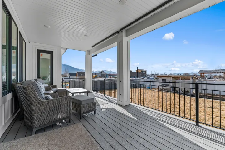 Expansive covered outdoor patio featuring composite decking and black metal railings