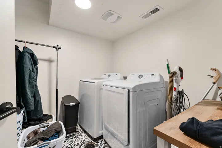 Dedicated laundry area featuring patterned tile flooring, a recessed ceiling light, and a white ceiling vent