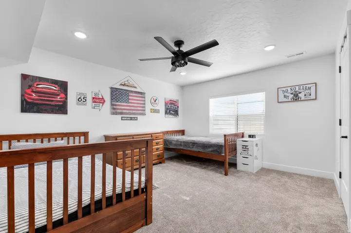 Spacious room featuring neutral carpeting, a ceiling fan with integrated lighting, recessed lighting, and a window with blinds