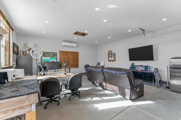 Spacious multi-purpose room featuring concrete flooring, recessed lighting, and a wall-mounted mini-split system