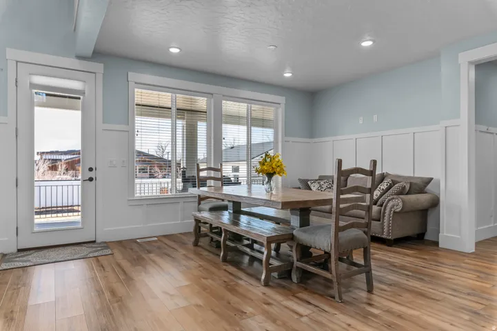 Spacious open-concept room featuring wood-finish flooring, recessed lighting, and board-and-batten wall detailing