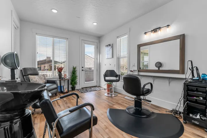 Spacious interior with wood-finish flooring, recessed lighting, and ample natural light from multiple windows and a glass-paneled door