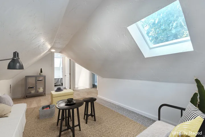 Sloped ceiling design with a skylight, recessed lighting, and carpet flooring