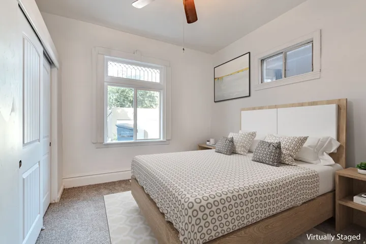 Recessed window with decorative transom, wood-finish ceiling fan, and carpeted flooring