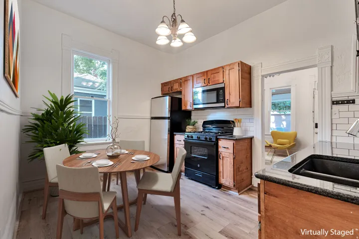 Wood-finish flooring, white subway tile backsplash, wood cabinetry, built-in microwave, and black gas range
