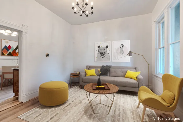 Living area featuring a contemporary chandelier, tall windows, and wood-finish flooring
