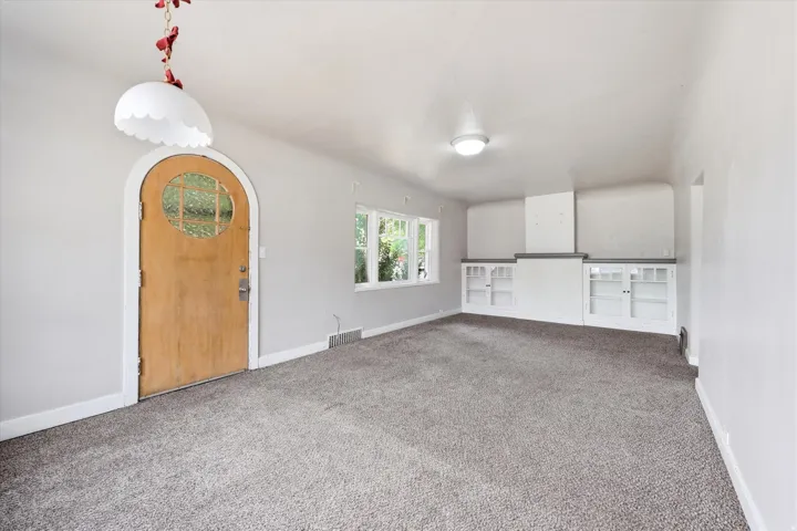 Spacious room with gray carpet flooring and light gray walls