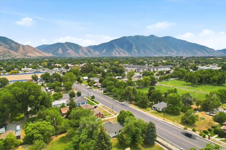 Expansive mountain range backdrop framing a residential area with mature trees and a wide thoroughfare