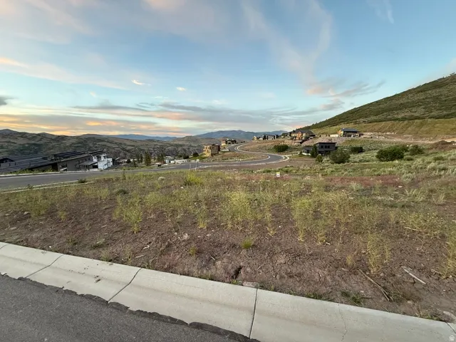 Expansive land parcel featuring existing hillside development and paved roads