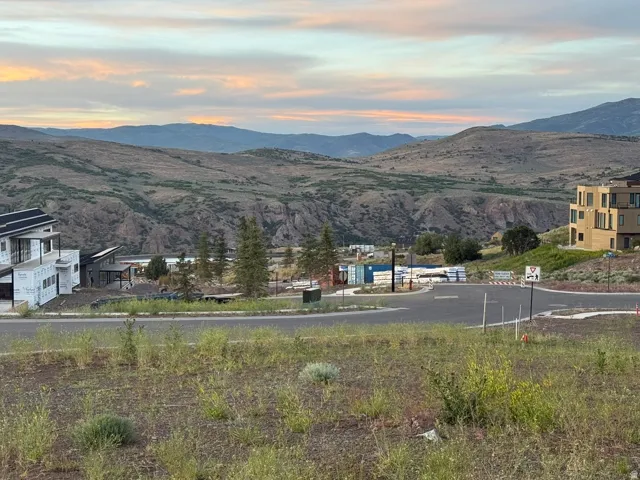 Expansive mountain backdrop with a visible road structure and varying architectural styles