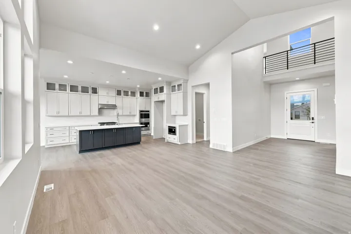 Expansive living space featuring wood-finish flooring and high vaulted ceilings