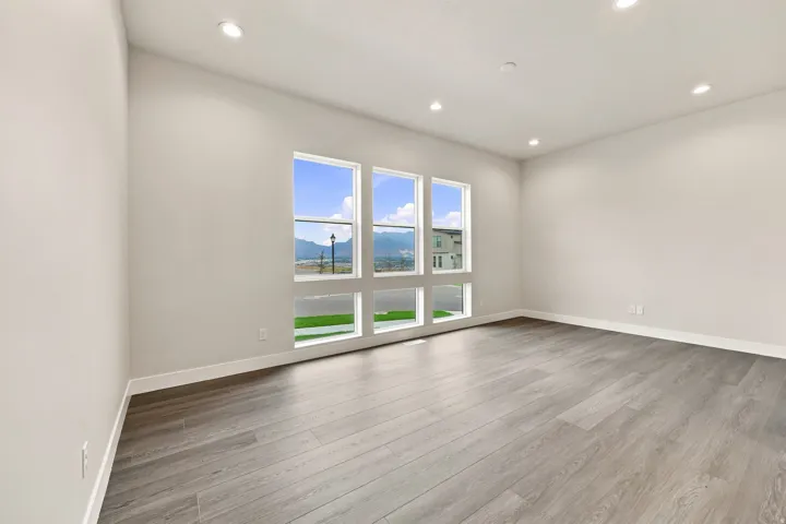 Recessed lighting, wood-finish flooring, white walls, and multiple windows