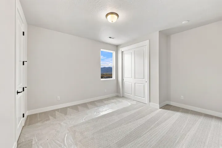 Neutral wall color with recessed lighting and a central flush-mount fixture