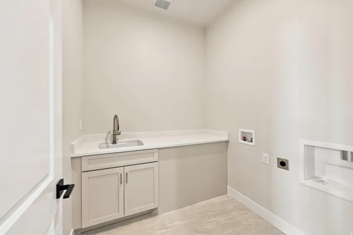 Light-toned wall paint, modern cabinetry, undermount sink, countertop, and tiled flooring