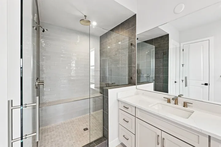 Walk-in shower with clear glass enclosure, a built-in bench, and a rain showerhead
