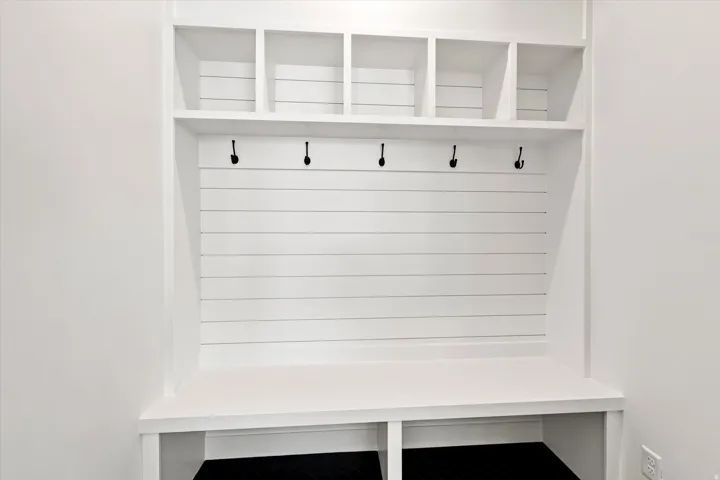 Built-in mudroom bench with cubby storage and black hooks