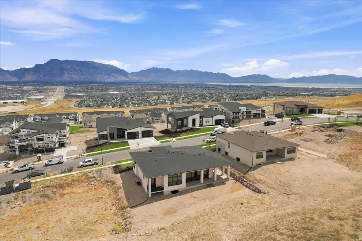 Semicustom residence with a covered patio, multiple large windows, and a two-car garage