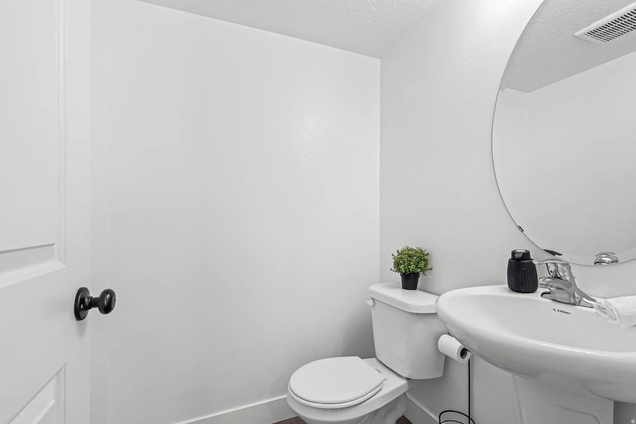 White pedestal sink with chrome faucet