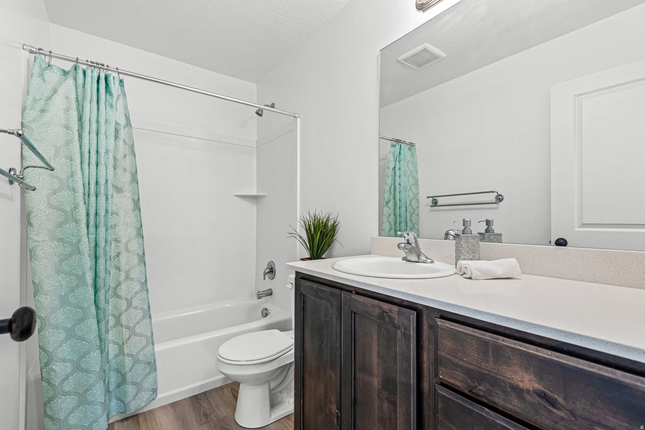 Bathroom featuring a vanity with dark wood-finish cabinetry, a white countertop, and an integrated sink with a chrome faucet