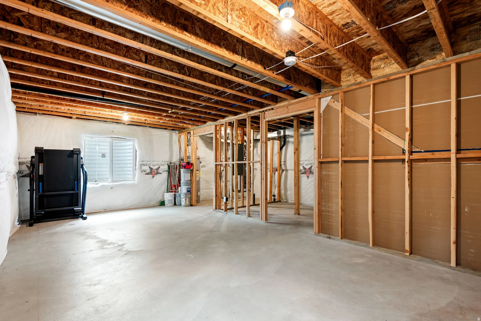 Unfinished basement featuring exposed wood joists and structural framing