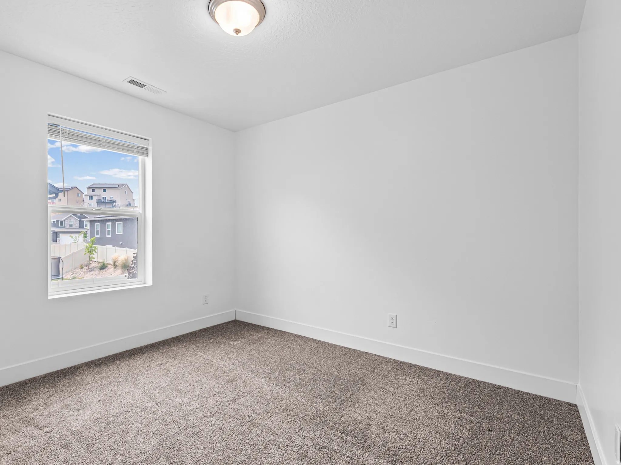 Carpeted interior space featuring a single window with blinds