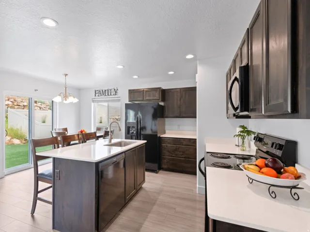 Modern kitchen featuring wood-finish cabinetry, light countertops, and stainless steel appliances
