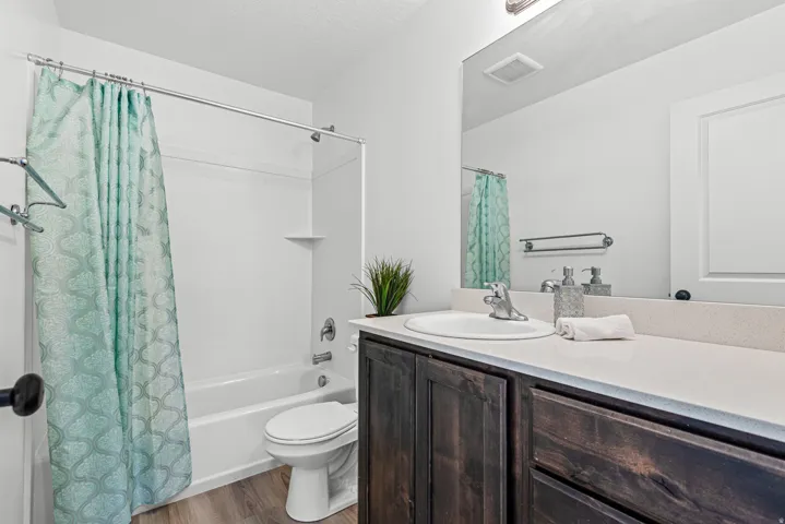 Bathroom featuring a vanity with dark wood-finish cabinetry, a white countertop, and an integrated sink with a chrome faucet