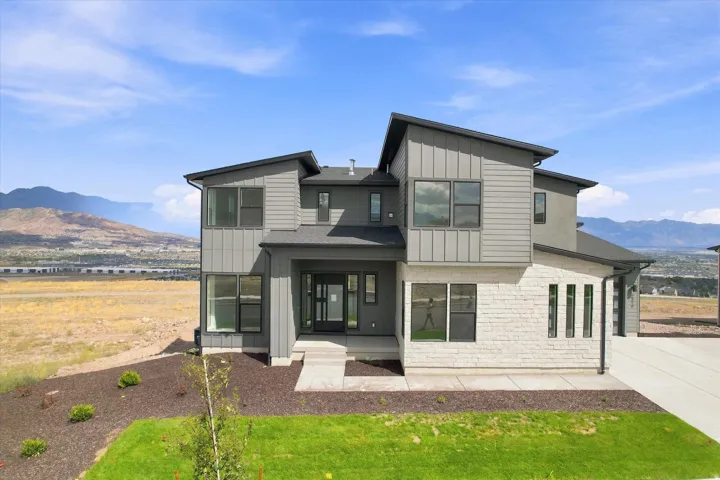 Modern exterior architecture featuring a prominent stone facade and contrasting vertical and horizontal siding