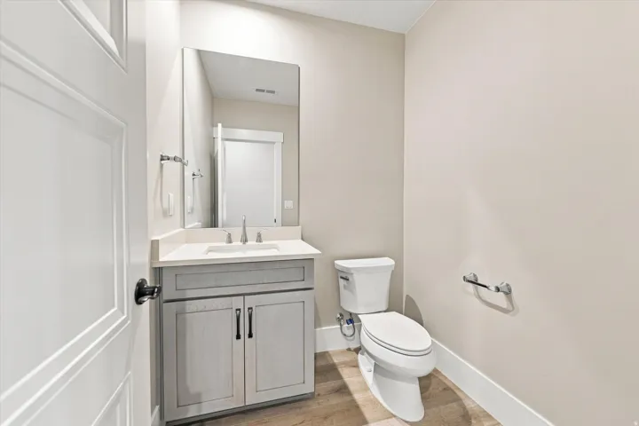 Vanity with light-colored countertop, undermount sink, and wall-mounted mirror