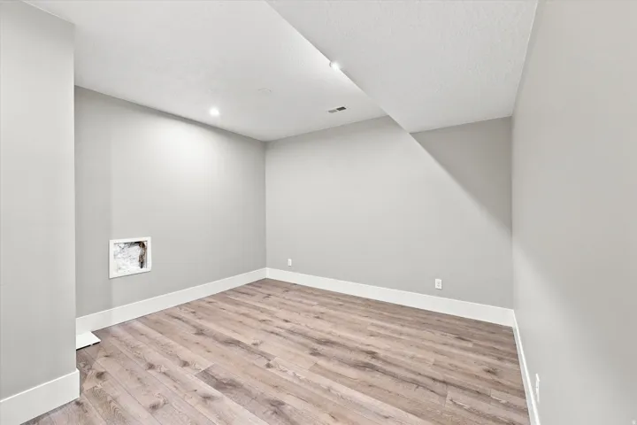 Recessed lighting, wood-finish flooring, white baseboards, and light gray walls
