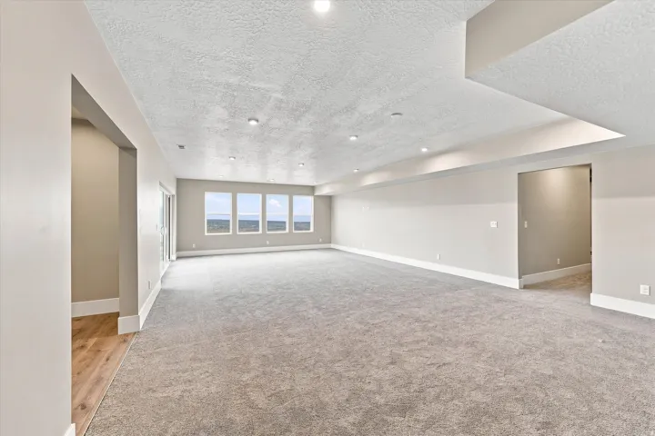 Spacious interior featuring carpet flooring, recessed lighting, multiple windows, and light-toned walls