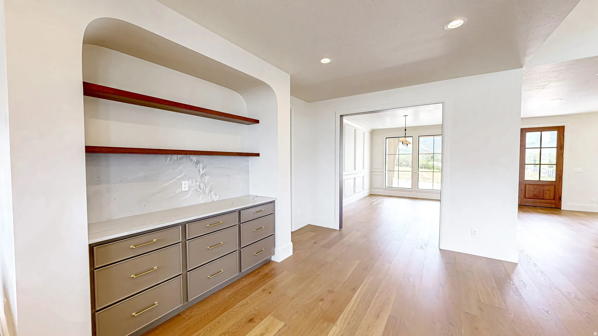 Built-in cabinetry with light-colored drawers, gold-finish hardware, and a stone-finish countertop