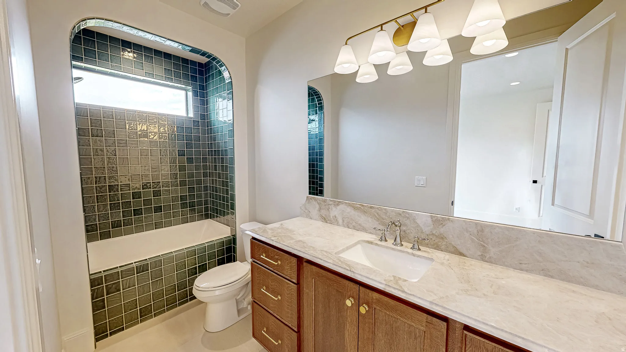 Subway tiled tub/shower combination with an arched alcove