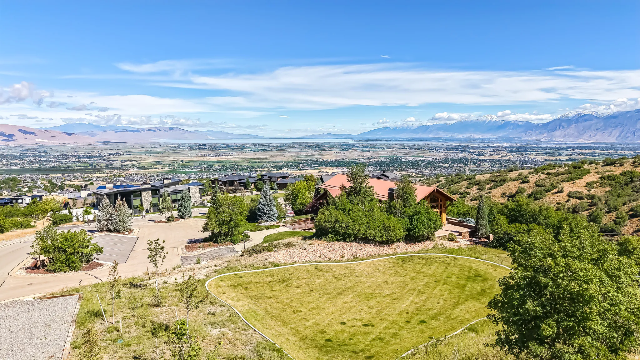 Expansive hillside property featuring a graded lawn area and established surrounding landscaping