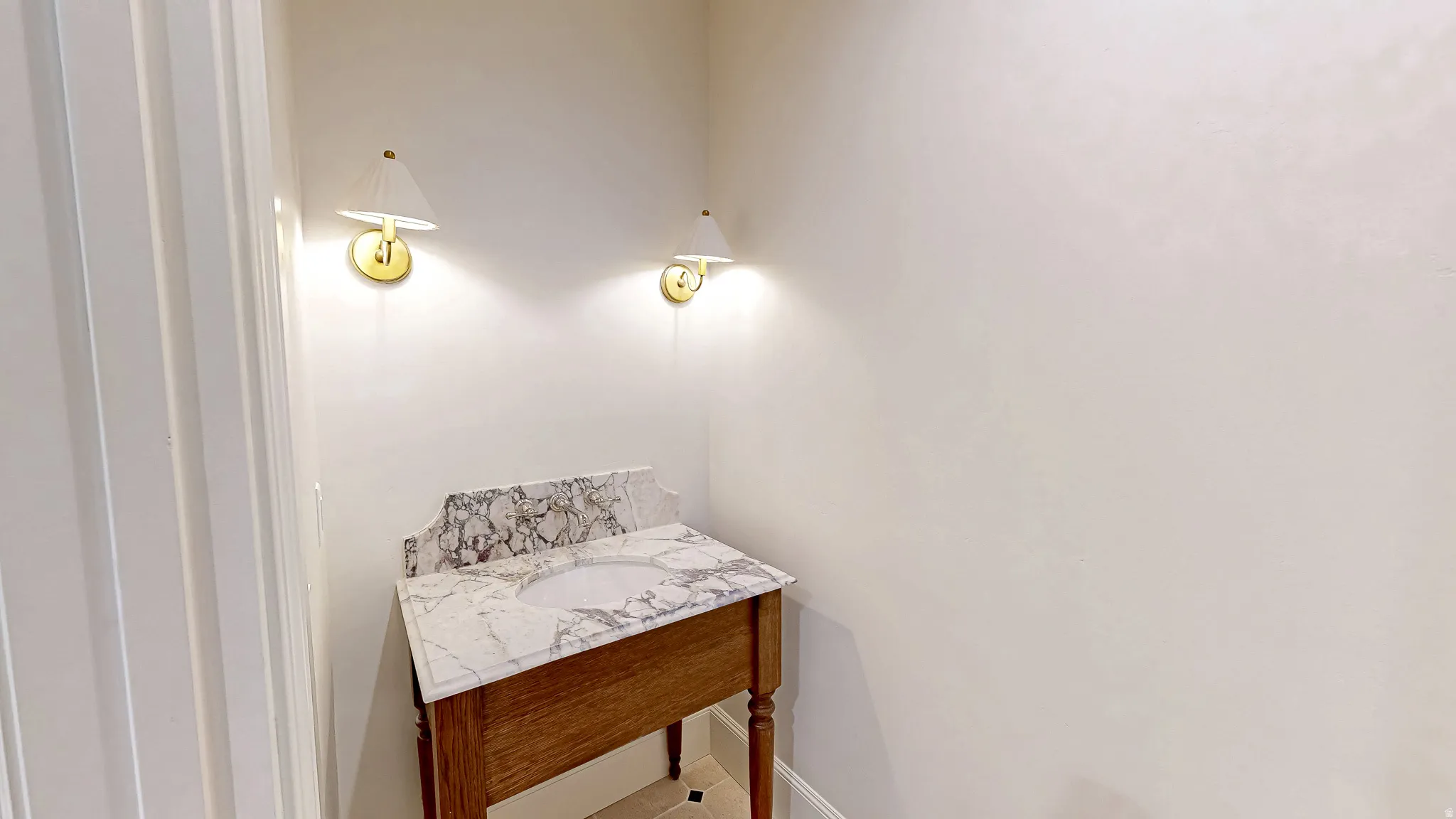 Vanity featuring a patterned stone countertop with an integrated sink and a wood-finish base