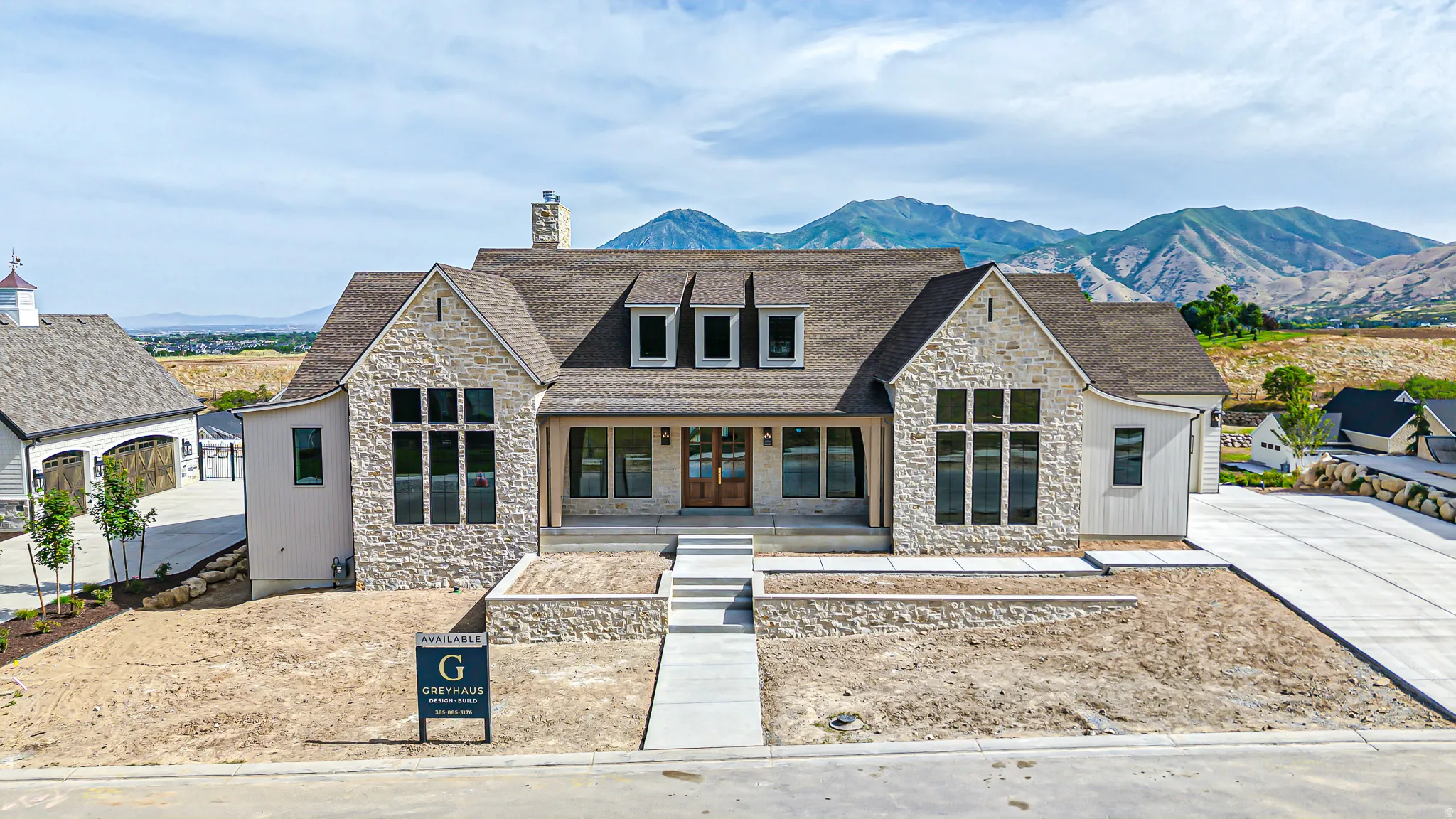 Stone and siding exterior with a prominent front entrance featuring double wood doors