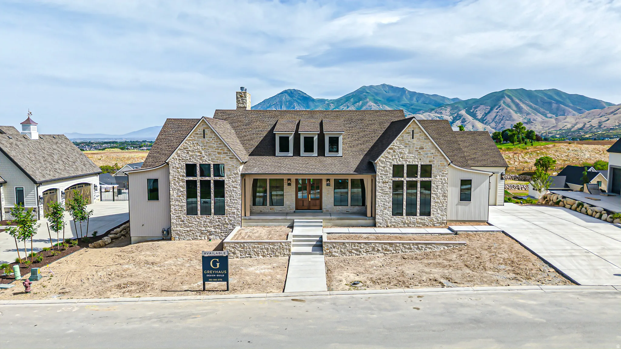 Stone and siding exterior with a prominent front entrance featuring double wood doors