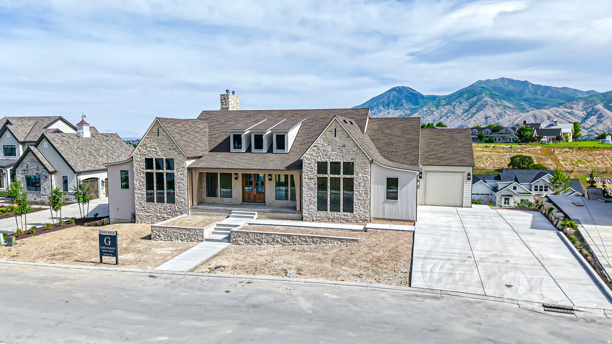 Stone and siding exterior with a prominent front entrance featuring a covered porch