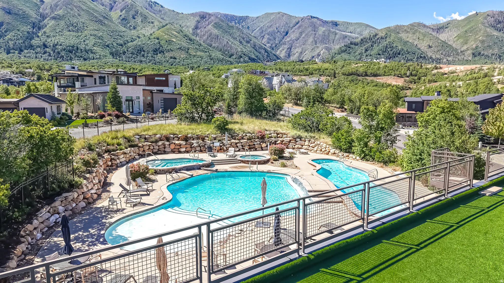 Resort-style pool area featuring two pools, two integrated spas, and surrounding lounge seating
